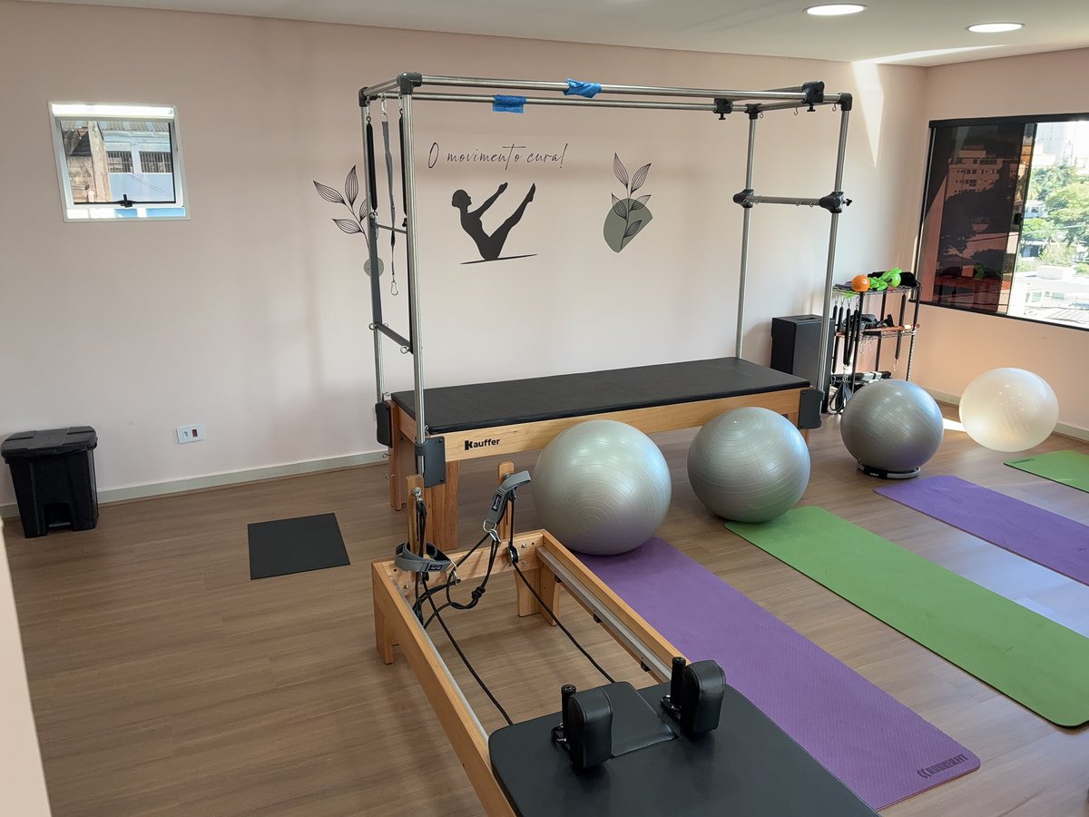 Aparelho cadillac e bola na sala de pilates de piso de madeira