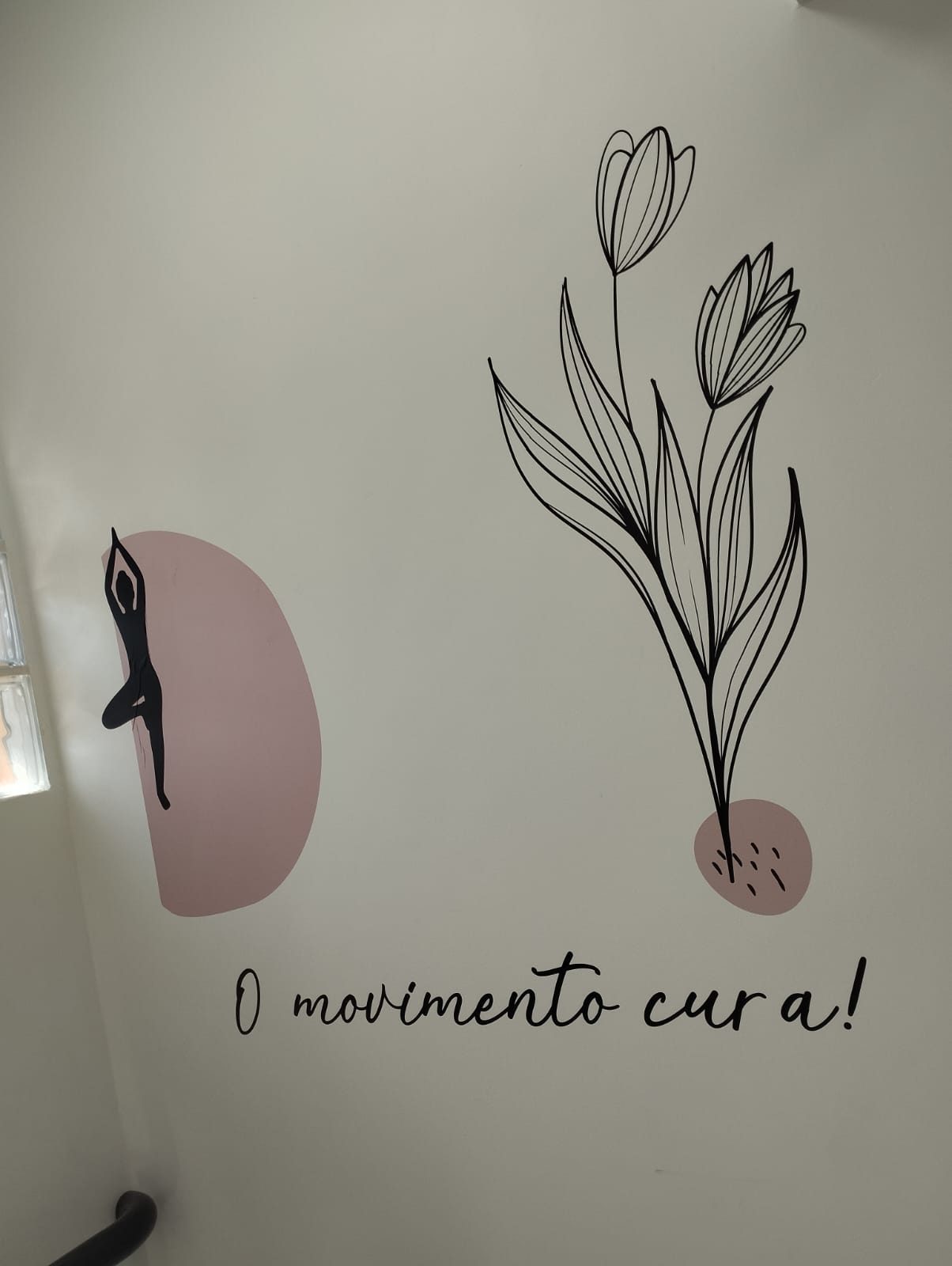 Mural no estúdio com a frase O movimento cura